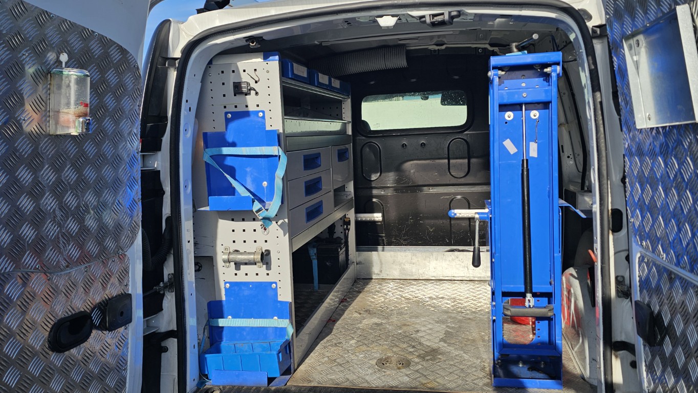 Renault Kangoo officina mobile bianco con scaffalature interne e banco morsa